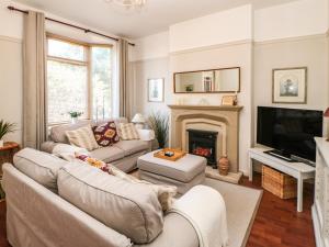 a living room with two couches and a fireplace at Pilgrim Cottage in Bishop Auckland