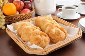 a basket of croissants and fruit on a table at Reikartz Sky Almaty in Almaty