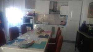 a kitchen with a table with chairs and a refrigerator at Casa Giulia in Porto SantʼElpidio
