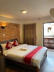 a bedroom with a bed with a brick wall at Hotel vintage Home in Bhaktapur