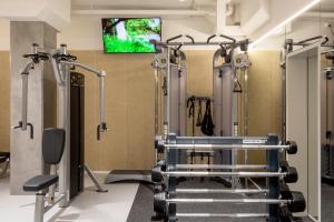 a gym with cardio equipment and a flat screen tv at Botanique Hotel Prague in Prague