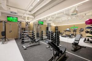 a fitness room with several treadmills and machines at Botanique Hotel Prague in Prague