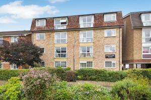 an apartment building with bushes in front of it at Surbiton modern 2 bedroom flat with parking in Surbiton
