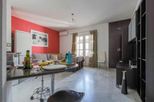 Apartamentos Alameda del Tajo I Parquing Centro في روندا: مطبخ بجدران حمراء وطاولة في الغرفة