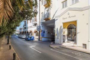 une rue avec des bâtiments et des voitures garés sur le côté de la route dans l'établissement Apartamentos Alameda del Tajo I Parquing Centro, à Ronda