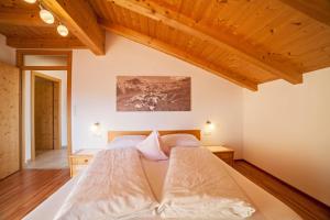 a bedroom with a large bed with wooden ceilings at Tonigbauernhof Blumenwiese in Schenna