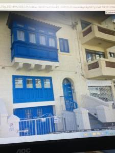 una foto di una casa con porte blu su uno schermo del computer di Modern Apartment in the Heart of Sliema Steps from the Seafront a Sliema