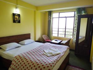 a bedroom with a bed with a red and white blanket at Hotel Himalaya Residency kanchenjunga view in Darjeeling