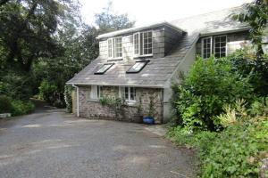 an old stone house with windows and a driveway at Lovely Spacious Cottage Near The Coast in St Austell