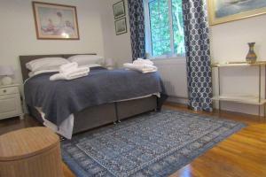 a bedroom with a bed and a blue rug at Lovely Spacious Cottage Near The Coast in St Austell