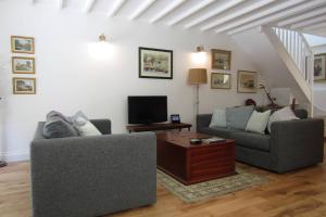 a living room with two couches and a tv at Lovely Spacious Cottage Near The Coast in St Austell