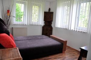 a bedroom with a bed and a chair and windows at Ferienhaus Pension Sonnenblume in Elmenhorst
