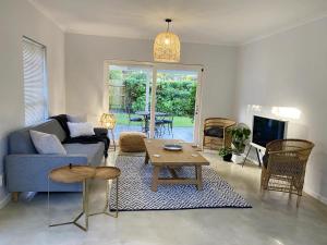 a living room with a blue couch and a table at Daisy Cottage in Hermanus
