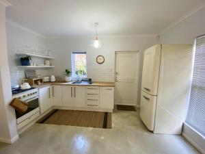 a kitchen with white appliances and a white refrigerator at Daisy Cottage in Hermanus +6 photos