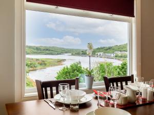 una mesa con vistas al río desde una ventana en The Woodfield Hotel en Clifden