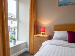 a bedroom with a bed and a window at The Woodfield Hotel in Clifden