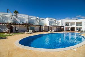 a large swimming pool in front of a building at Cliff-Top Townhouse with Stunning Ocean Views in Carvoeiro