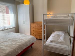una camera con letto a castello, letto e cassettiera di Holiday Home Weekendhuisje a Nieuwpoort