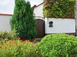 a house with a wooden gate in a garden at Ferienhaus Christine in Schenkendöbern +6 photos