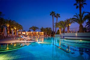 a hotel pool with a person sitting in a chair next to it at Lagomandra Hotel and Spa in Lagomandra