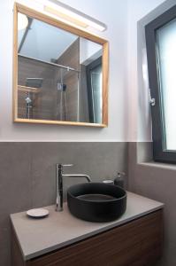 a bathroom with a black sink and a mirror at Skyline Resort in Balatonalmádi