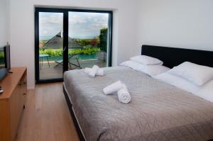 1 dormitorio con 1 cama con 2 toallas en Skyline Resort, en Balatonalmádi