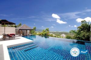 a swimming pool with blue walls and a blue sky at The Pavilions, Phuket - SHA Extra Plus in Bang Tao Beach