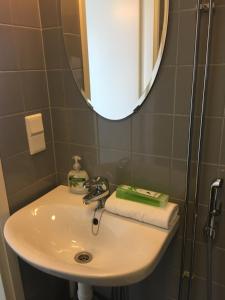 a bathroom sink with a mirror and a shower at Hjalmar’s Hotel in Korppoo +32 photos