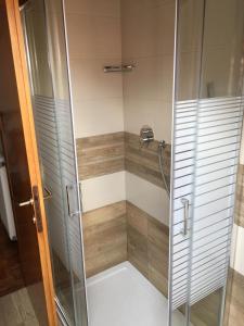 y baño con ducha y puerta de cristal. en La Mansarda di Sabina. en Fiera di Primiero