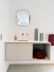 a bathroom with a white sink and a mirror at Le Nine, b&b au coeur de Falaën in Falaën