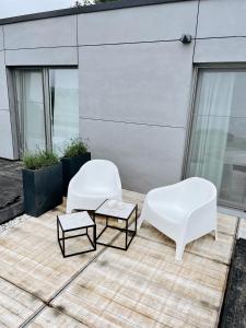 two white chairs and a coffee table on a patio at Le Nine, b&b au coeur de Falaën in Falaën