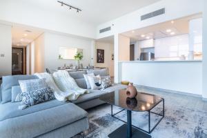 - un salon avec un canapé et une table dans l'établissement EDEN'S Homes & Villas - Millennium Atria Residences, à Dubaï