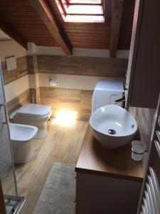 La salle de bains est pourvue d'un lavabo, de toilettes et d'une fenêtre. dans l'établissement La Mansarda di Sabina., à Fiera di Primiero