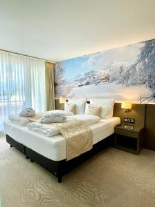 - une chambre avec un grand lit orné d'une peinture murale dans l'établissement Alpenlodge Val Gronda, à Obersaxen