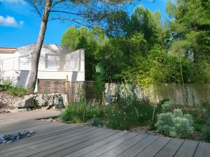 a garden with a wooden deck in front of a house at Studio d'Hôtes les Libellules in Castelnau-le-Lez