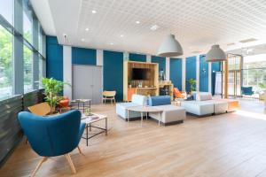 Appart'City Confort Toulouse Diagora Labège في لابيج: غرفة معيشة بجدران زرقاء وأثاث أبيض