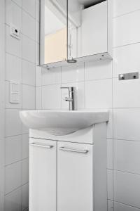 a white bathroom with a sink and a mirror at Skärgårdsbyn Hotell in Sankt Anna