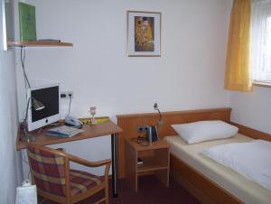 a bedroom with a desk and a bed with a computer at Zu Müllers Winkelhausen in Langenmosen
