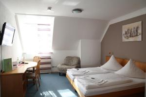 um quarto com uma cama, uma secretária e uma cadeira em Zu Müllers Winkelhausen em Langenmosen
