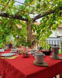 uma mesa com uma toalha de mesa vermelha com comida em Villa Maddalena em Bra