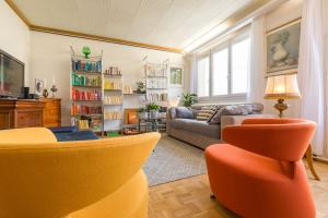 sala de estar con sillas de color naranja y sofá en Appartement Climatisé 100M2 7mn Centre Ville Garage 5Pièces 5 Adultes Bébé Arrivée Autonome, en Dijon