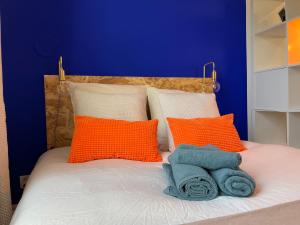 a bed with orange and blue pillows on it at Studio design Bleu Alpin in Le Mont-Dore