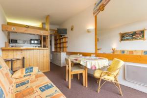 a room with a bed and a table and chairs at travelski home classic - Résidence les Lauzières in Arc 1800 +9 photos