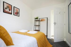 a bedroom with a bed with a yellow blanket at Links to M62 - 3 bedroom property in Golcar
