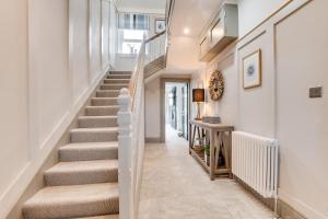 a staircase in a home with white walls and carpeted floors at Castle View by Coast & Country Stays in Bamburgh +56 photos