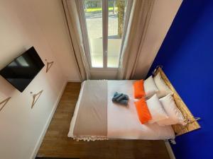 a room with a bed with pillows and a window at Studio design Bleu Alpin in Le Mont-Dore