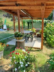 a wooden pergola with a table and some flowers at Appartamento Il GIRASOLE in Scarperia