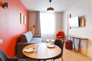 - un salon avec une table et un canapé dans l'établissement Appart'City Confort Toulouse Diagora Labège, à Labège