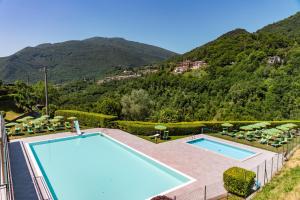 Elle offre une vue sur la piscine et les montagnes en arrière-plan. dans l'établissement Residence Casa Gardola, GTSGroup, à Tignale