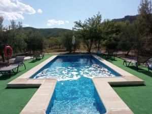 una piscina con acqua blu in un cortile di El Valle de Yeste a Yeste